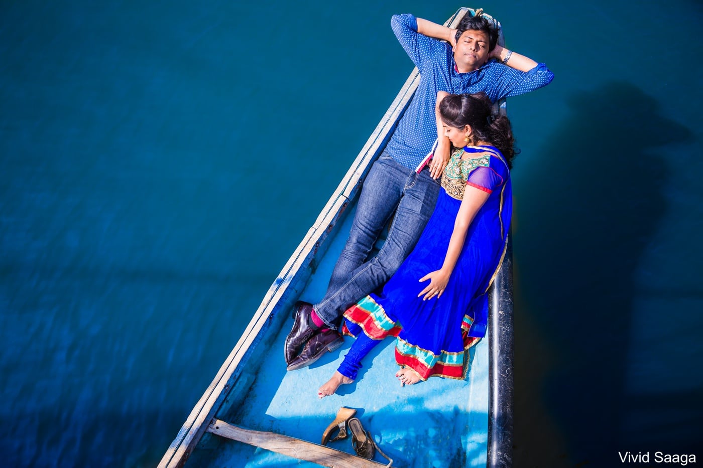 bride and groom lying in a boat during couple shoot